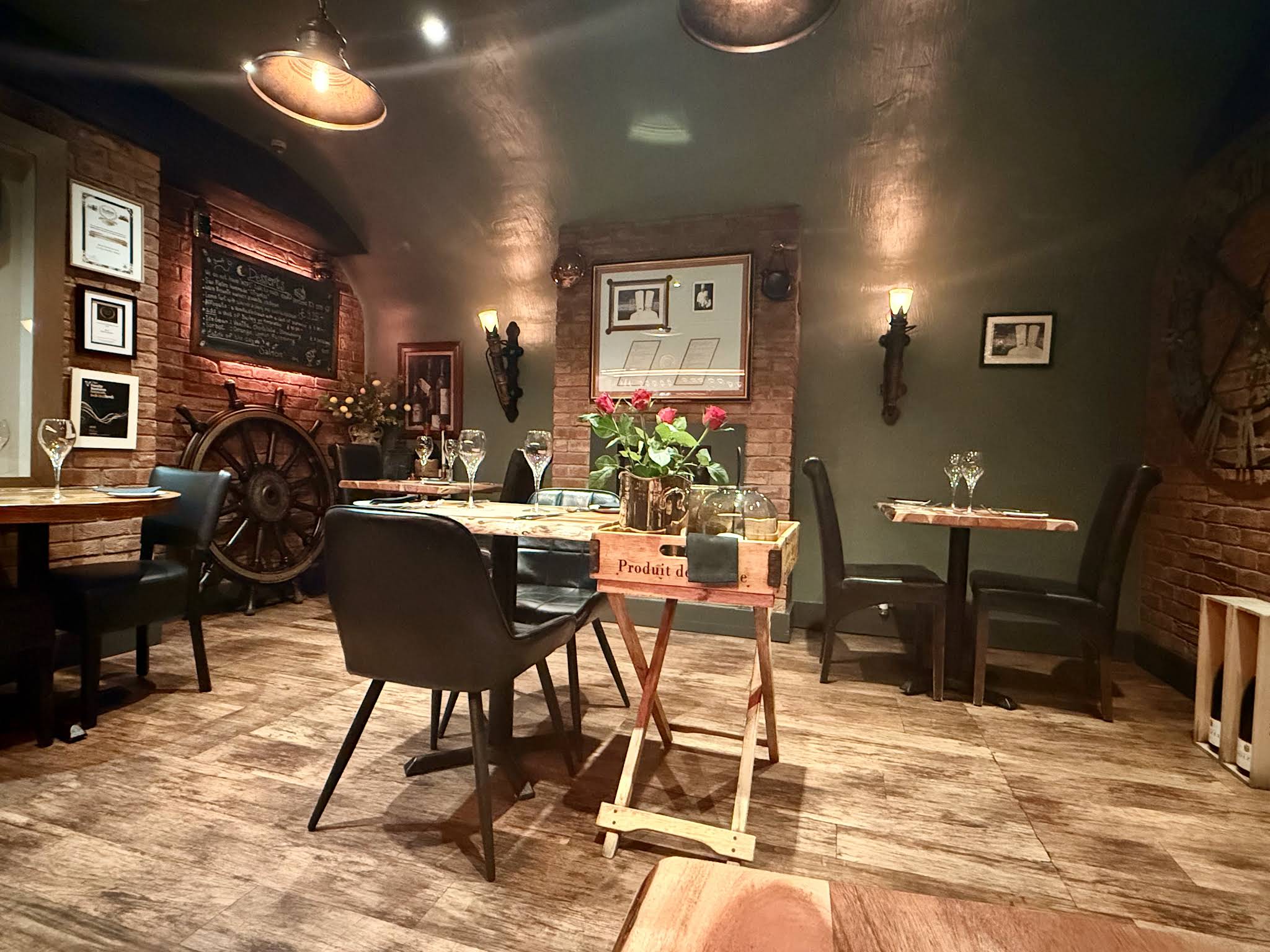 San Pietro’s dining room with brick walls, wooden tables, flowers, wine glasses and warm wall lights